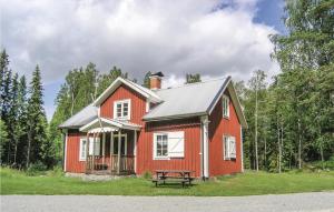 een rood huis met een bank ervoor bij Gorgeous Home In Vislanda With Kitchen in Vislanda