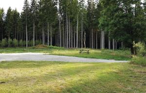 a picnic table in the middle of a field with trees at One-Bedroom Holiday Home In Vislanda in Vislanda