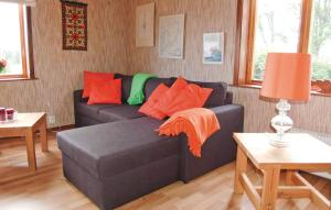 a living room with a blue couch with orange pillows at Holiday Home Spångens Motorbåtsklubb Åsensbruk in Åsensbruk