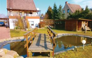 a bridge over a pond in a yard with a house at 1 Bedroom Cozy Apartment In Marlow in Blankenhagen +6 photos