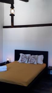 a bed with two pillows on it in a room at Palheiros de Mira in Praia de Mira
