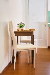 a dining room table with two chairs and a table with a plant at Emmanouela's Apts in Kissamos