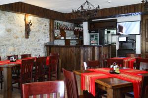 a restaurant with wooden tables and chairs and a bar at Galabova Guesthouse in Delchevo