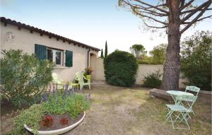 un patio trasero con mesa, sillas y un árbol en 1 Bedroom Awesome Home In Visan, en Visan
