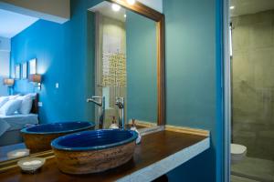 LUWİ ANTAKYA BOUTİQUE HOTEL في هاتاي: حمام جدارين زرقين ومغسلة