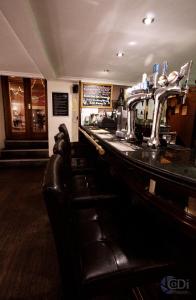 a bar with black leather seats in a restaurant at Forresters Bar & French Restaurant with Rooms in Middleton in Teesdale