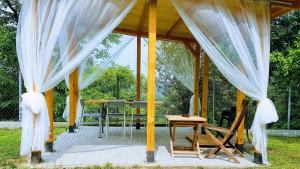 a gazebo with a table and chairs and curtains at Cracow Family House in Kraków
