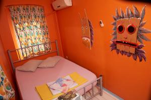 イスタンブールにあるチルアウト リヤ ホステル ＆ ラウンジのオレンジ色の壁のベッドルーム1室、ベッド1台(壁にマスク付)
