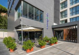 a building with tables and chairs and an umbrella at Camplus Guest Roma Casa per Ferie in Rome