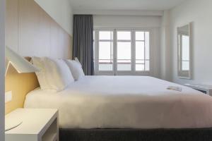 a large white bed in a room with a window at Stay Hotel Coimbra Centro in Coimbra