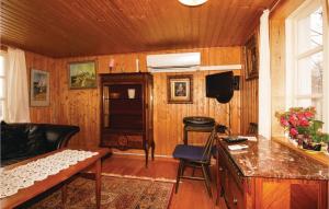 a living room with wood paneling and a television at Gorgeous Home In Dalstorp With Kitchen in Dalstorp