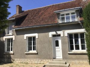 a gray house with a white door and windows at La vallée des pierres in Saint-Romain-sur-Cher