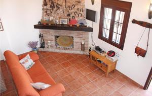 フリヒリアナにあるNice Home In Frigiliana With House A Mountain Viewのリビングルーム(オレンジ色のソファ、暖炉付)