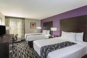 
a hotel room with two beds and two lamps at La Quinta by Wyndham Orlando Universal area in Orlando
