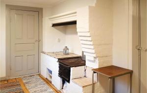 a kitchen with an old stove and a white wall at One-Bedroom Holiday Home In Vislanda in Vislanda +9 photos
