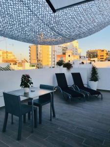 a patio area with chairs, tables, and umbrellas at Hostal El Caprichito Marbella in Marbella