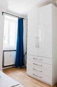a bedroom with a white dresser and a window at Beautiful Park Apartment for 4 Guests in Berlin
