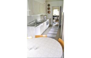 a white kitchen with a table and a sink at 4 Bedroom Awesome Home In Eksj in Berghemmet