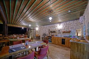a restaurant with wooden ceilings and wooden tables and chairs at Taru Cave Suites in Urgup