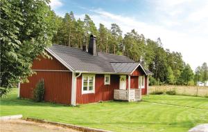 KvänarpにあるBeautiful home in Vittaryd with 2 Bedrooms and WiFiの草の木の庭の赤い家
