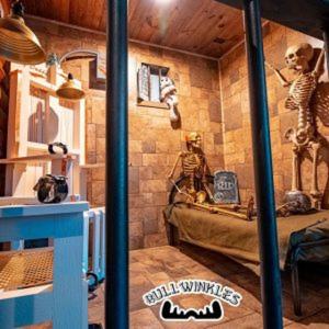 um quarto com uma cama num quarto com uma parede com esqueletos em Bullwinkles Rustic Lodge em Poplar Bluff