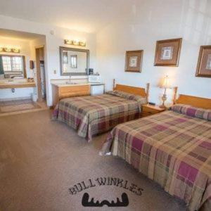 Bullwinkles Rustic Lodge في بوبلار بلاف: غرفة فندقية بسريرين ومغسلة