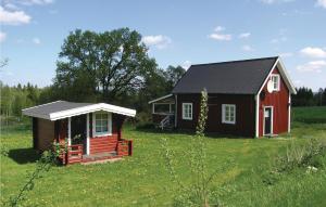 a small red house in a grassy field at Gorgeous Home In Dalstorp With Kitchen in Dalstorp