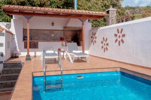 une terrasse avec une piscine et une maison dans l'établissement Villa privada con piscina agua salada, barbacoa y chimenea - El Amanecer, à Breña Baja