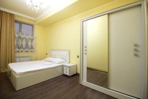 a bedroom with a bed and a mirror at AL SHEIKH 5 BEDROOM LUXURY APARTMENT 1 in Yerevan