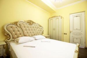 a bedroom with a white bed with a large headboard at AL SHEIKH 5 BEDROOM LUXURY APARTMENT 1 in Yerevan