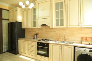 a kitchen with white cabinets and a black refrigerator at AL SHEIKH 5 BEDROOM LUXURY APARTMENT 1 in Yerevan