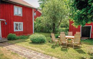 ビンメルビューにあるBeautiful Home In Vimmerby With 3 Bedrooms And Wifiの赤い納屋の前の椅子