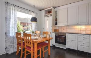 uma cozinha com uma mesa de madeira com cadeiras e uma janela em Gorgeous Home In Sollebrunn With Wifi em Sollebrunn