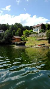 a body of water with houses in the background at La Combe fleurie in Villers-le-Lac