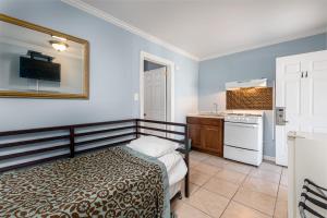 a bedroom with a bed and a kitchen with a sink at Boardwalk Hotel Charlee & Apartments Beach Hotel Oceanfront in Seaside Heights