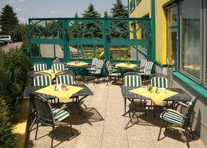 grupa stołów i krzeseł na patio w obiekcie Hotel Asperner Löwe w Wiedniu