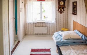 a small bedroom with a bed and a window at 3 Bedroom Lovely Home In Vimmerby in Vimmerby +2 photos