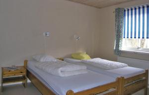 2 camas individuales en una habitación con ventana en Holiday Home Agunnaryd with Fireplace VII, en Agunnaryd