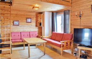 a living room with red furniture and a television at Cozy Apartment In Trysil With Sauna in Trysil