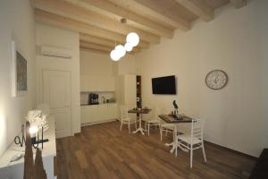a living room with a table and chairs and a clock at B&B Palazzo San Michele in Bari