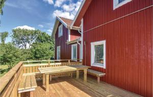 a wooden deck with a bench on the side of a red building at 4 Bedroom Nice Home In Sollebrunn in Sollebrunn