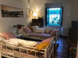 een woonkamer met 2 bedden en een bank bij Apartamento Suite Las Setas in Sevilla