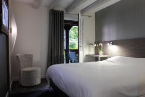 A bed or beds in a room at Hotel Restaurant Père Benoît