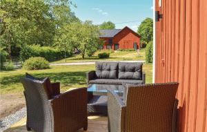 een patio met 2 stoelen en een tafel en een rode schuur bij Cozy Home In Herrng With Wifi in Herräng