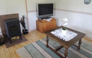 a living room with a television and a table and a stove at Awesome Home In Ljungby With Sauna in Ljungby