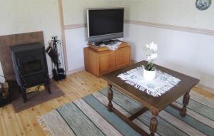 ユングビューにあるAmazing home in Ljungby with 1 Bedrooms and Saunaのリビングルーム(テレビ、テーブル、コンロ付)