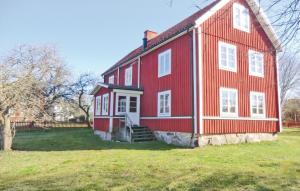 une grande maison rouge avec un champ vert devant elle dans l'établissement Gorgeous Home In rsj With Wifi, à Kopparfly