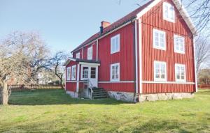 een groot rood huis met een groen veld ervoor bij Awesome Home In rsj With 4 Bedrooms And Wifi in Kopparfly