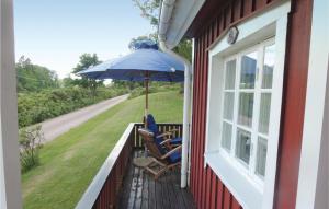 ユングビューにあるAmazing home in Ljungby with 1 Bedrooms and Saunaの椅子2脚と傘付きのポーチ