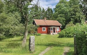 une maison rouge au milieu d'une cour dans l'établissement Awesome Home In Falkping With 1 Bedrooms, à Broddetorp